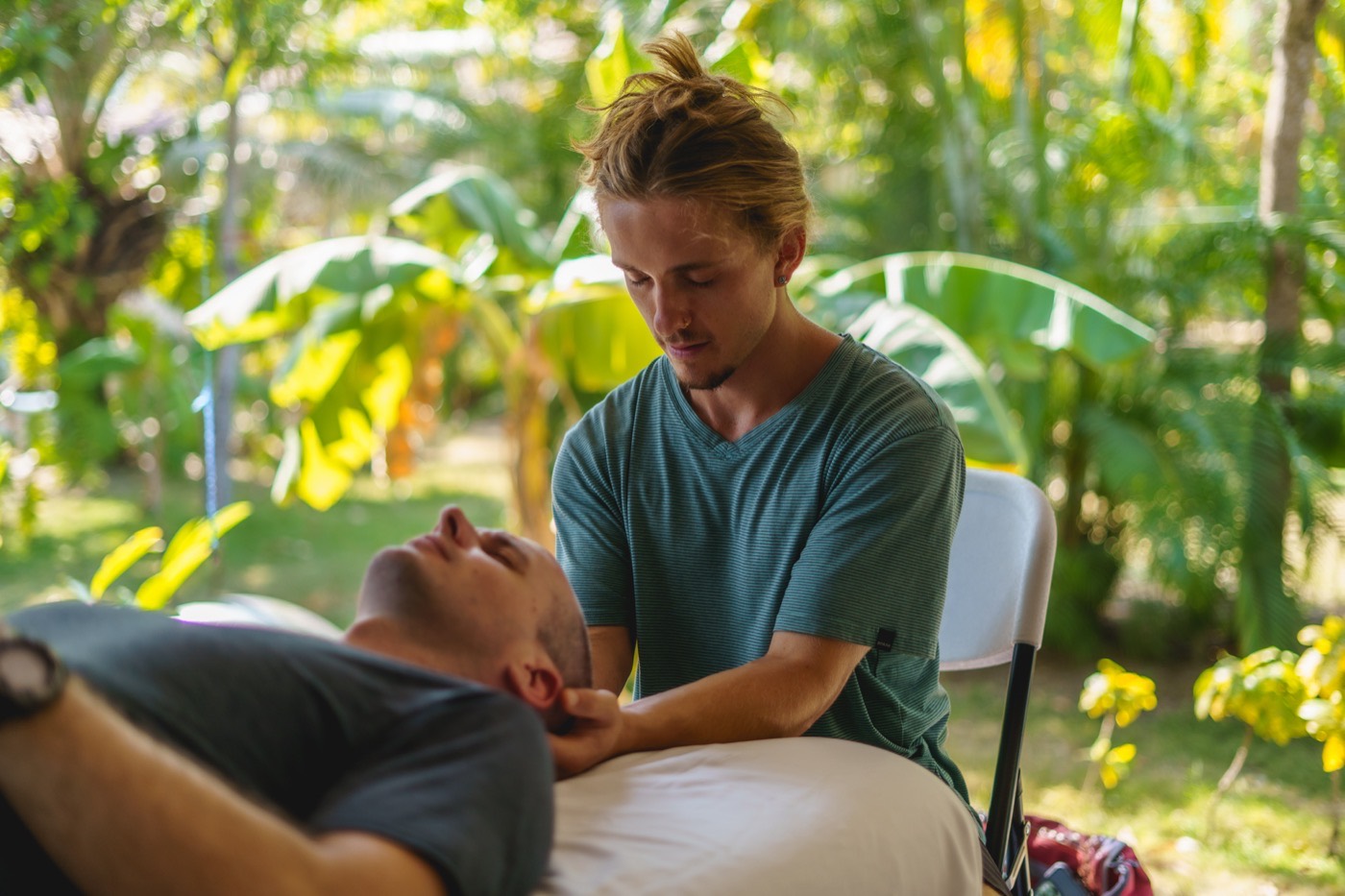 Willoughby Bourne working with both hands supporting a client&rsquo;s head and neck during a session